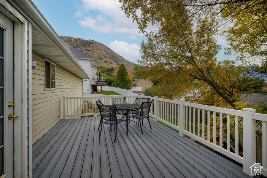 New composite deck with white railings, a dining table, and mountain views